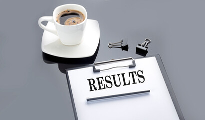 RESULTS text on paper sheet with coffee on the black background