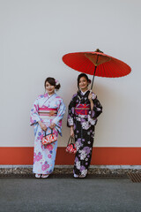 Storytelling image of two japanese girls wearing kimono spending time in Tokyo. Traditional clothes...