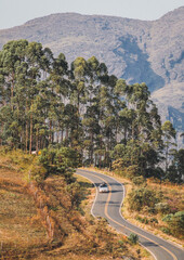 Carro trafegando em estrada com montanhas ao fundo em Lavras novas, Minas Gerais