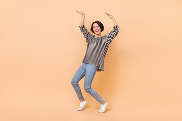 Fototapeta na wymiar Full body photo of young cheerful girl have fun dance performance isolated over beige color background
