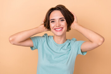 Photo of young lovely cheerful girl hands touch hair enjoy new hairdo isolated over beige color background