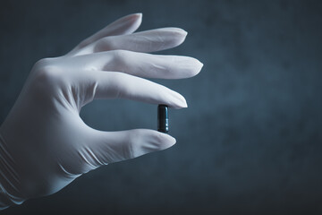 Pharmacist hand holding a pills. Female hand with a medicine white gloves. Concept of medicine.