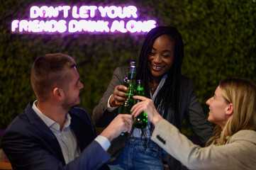 Colleagues working on a laptop and having a meeting in a cafe while toasting