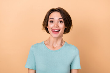Photo of young pretty lady dreamy lick teeth tasty dessert dentist clinic isolated over beige color...
