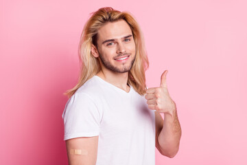 Photo of charming young positive man make thumb up vaccination isolated on pastel pink color background