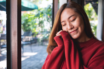 Portrait image of a beautiful young asian woman in red sweater