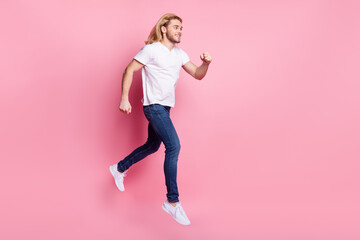 Fototapeta na wymiar Full body photo of positive young man jump up run empty space isolated on pastel pink color background