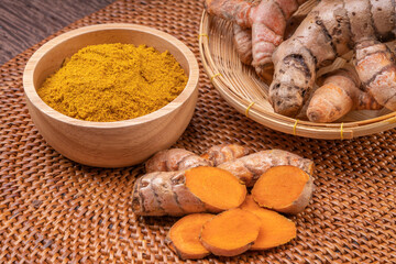 Curry Powder and Turmeric root in wooden plate, Curry Powder on a wooden table background.