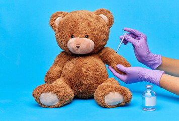 vaccination, healthcare and pandemic concept - hands of doctor in medical gloves with vaccine and...