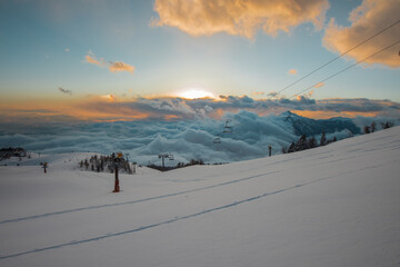 Top of the krvavec ski slope, bathing in the last rays of sun setting behind clouds.