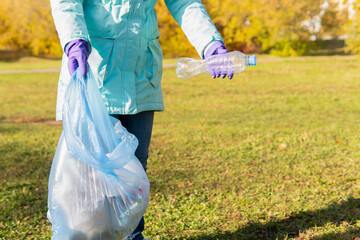 A female volunteer cleans plastic garbage in nature.