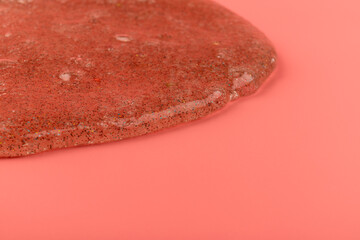 Coral transparent slime with bubbles inside on pink background. Kids toy slime.