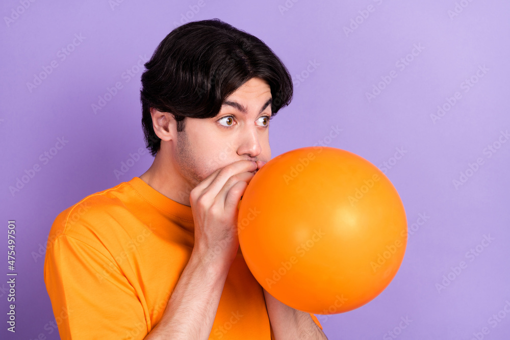 Sticker Photo of young happy funky positive man hold hands balloon inflate blow air isolated on violet color background