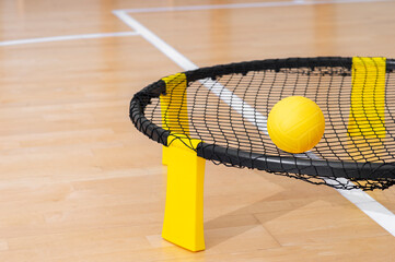 Spike ball game with yellow ball on hardwood court floor. Horizontal sport theme poster, greeting...