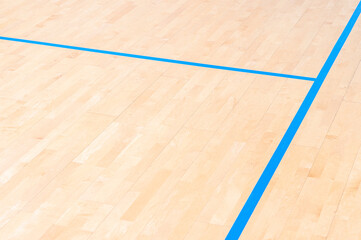 Wooden floor  basketball, badminton, futsal, handball, volleyball, football, soccer court. Wooden floor of sports hall with marking blue lines on wooden floor indoor, gym court