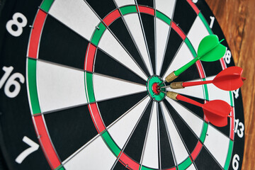 Concept of competition and goal achievement.Achieving goals in business and life.Dartboard with three darts stuck right center of target.