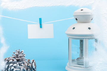Christmas lantern with New Year's attributes and snow over on blue background.