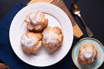 Food concept Homemade fresh baked Choux a la creme, Cream Puff, Choux Cream in white ceramic plate on black background with copy space