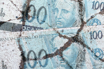 On the cracked asphalt there is an image of the Brazilian real.