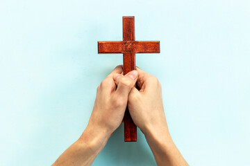 Obraz premium Hands holding christian wooden cross. Faith and prayer concept
