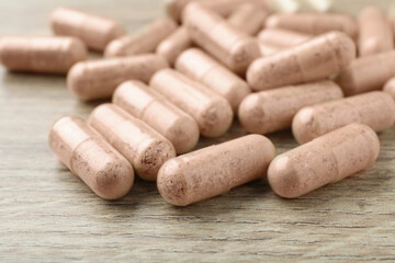 Gelatin capsules on wooden table, closeup view