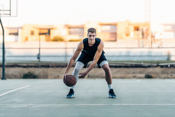 Basketball player bouncing the ball on an outdoor court