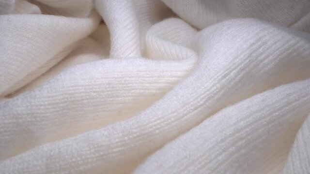 Cozy sheep white wool fabric texture in macro. Handcraft knitting woolen sweater. Soft textile abstract background. Winter fashion clothing industry. Home comfort and cosiness
