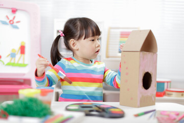 young girl making bird hourse craft for home schooling