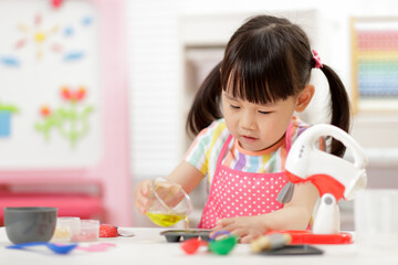 young  girl pretend play food preparing at home