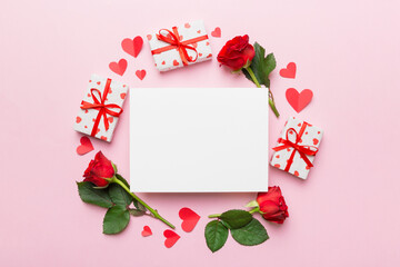 Frame made of rose, git box, heart and blank greeting card mockup on Colored background. Top view, flat lay, copy space Holiday, Mothers Day, birthday concept
