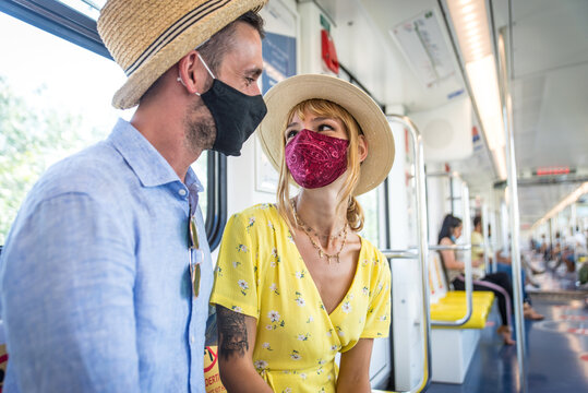 Image of a happy couple sitting in the metro commuter during 2020 pandemic events