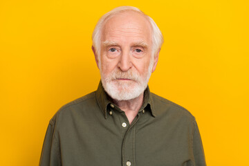 Obraz premium Photo of strict old beard man wear khaki shirt isolated on yellow color background