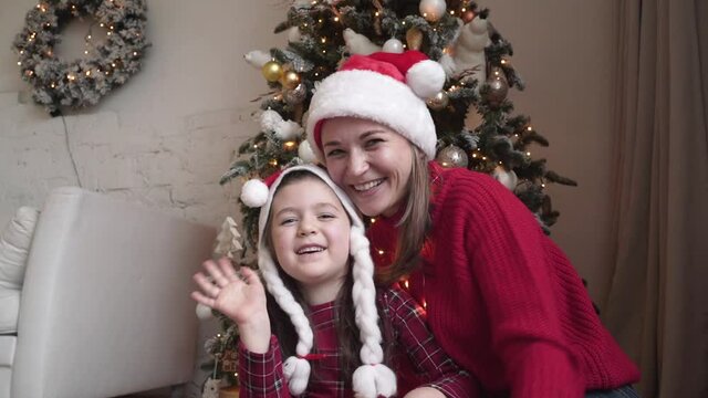 Mother with a child is celebrating Christmas with their friends using video call