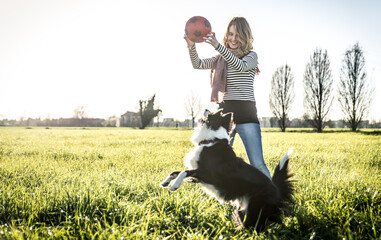 Beautiful woman with her loyal border collie dog at the park