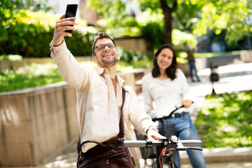 Happy young couple outdoors. Loving couple with bicycle in the park