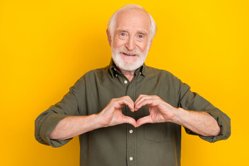 Photo of cheerful candid aged person hands fingers make heart symbol isolated on yellow color...
