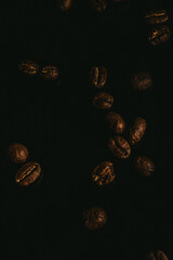 Fresh roasted coffee beans closeup on black a background. Top view, flat lay with copy space