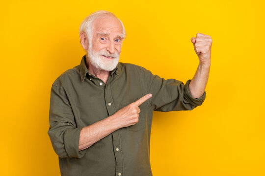 Photo Of Positive Handsome Person Indicate Finger Arm Flexing Biceps Isolated On Yellow Color Background