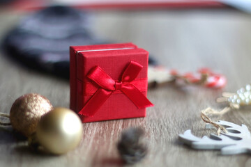 Wool stocking with small presents and Christmas decorations on wooden background. Selective focus.