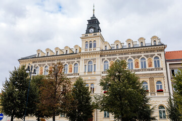Fototapeta na wymiar Louny, Czech Republic, 19 September 2021: Neo-Renaissance town hall at main Peace square or Mirove namesti, building with sgraffito mural and clock tower and sculptures allegories on autumn day