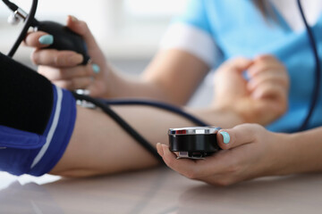 Doctor measuring patients blood pressure with tonometer tool on planned appointment
