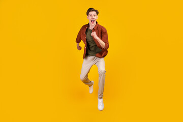 Fototapeta na wymiar Full size photo of young crazy man amazed shock jump run hurry isolated over yellow color background
