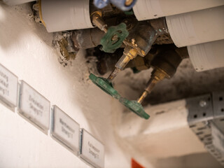 Insulated pipes for gas and water on the ceiling with green valve