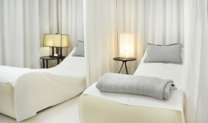 Beautiful luxurious white interior of a private massage room with two beds for two people to relax and in a modern wellness spa