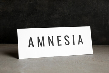 Card with word Amnesia on light grey table