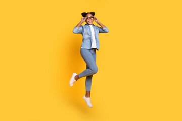 Fototapeta na wymiar Full size profile side photo of young cheerful african lady jump eyewear energetic isolated over yellow color background