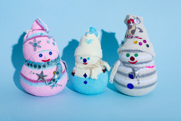 Diy handmade snowmen on a blue background. Christmas snowmen from waste.