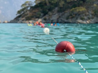 Beach buoys on a rope in the sea. A marker for swimming in blue water. Swimming lane in the...