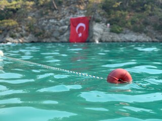 Beach buoys on a rope in the sea. A marker for swimming in blue water. Swimming lane in the Mediterranean. Concept: swimming in the warm sea, water sports.