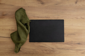 Top view of slate tray,board and green linen napkin on the wooden table